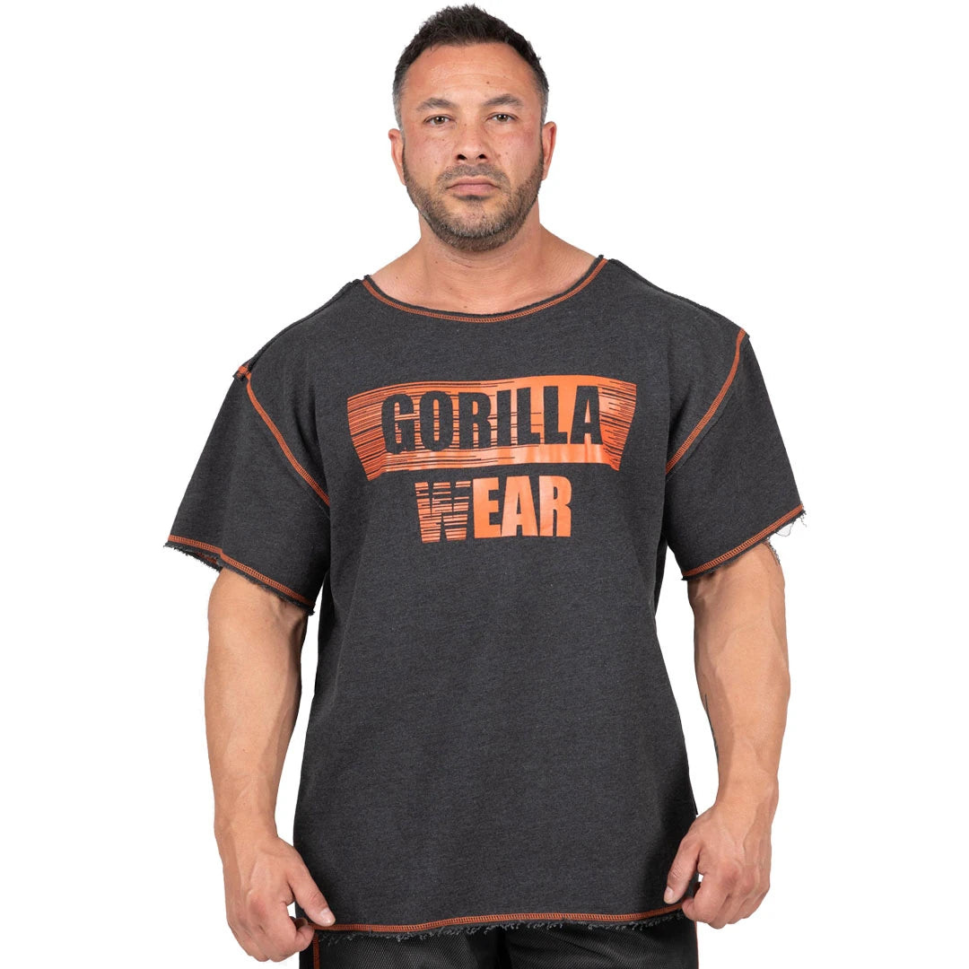 Tummanharmaa Gorilla Wear Wallace Workout Top Grey/Orange -oversized-treenipaita, jossa on oranssi logo ja raakareunat.