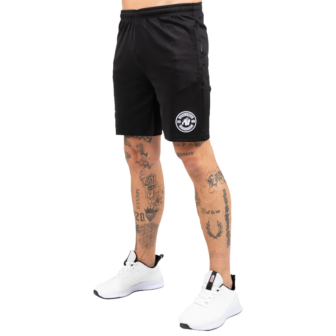 Gorilla Wear Vernon Track Shorts Black -mustat treenishortsit valkoisella logolla tatuoidun mallin yllä., kuva 2/7