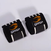 Vahvat mustat GASP Hardcore Wrist Wraps Black/White -rannesiteet joustavaa kangasta valko-oranssilla logolla.