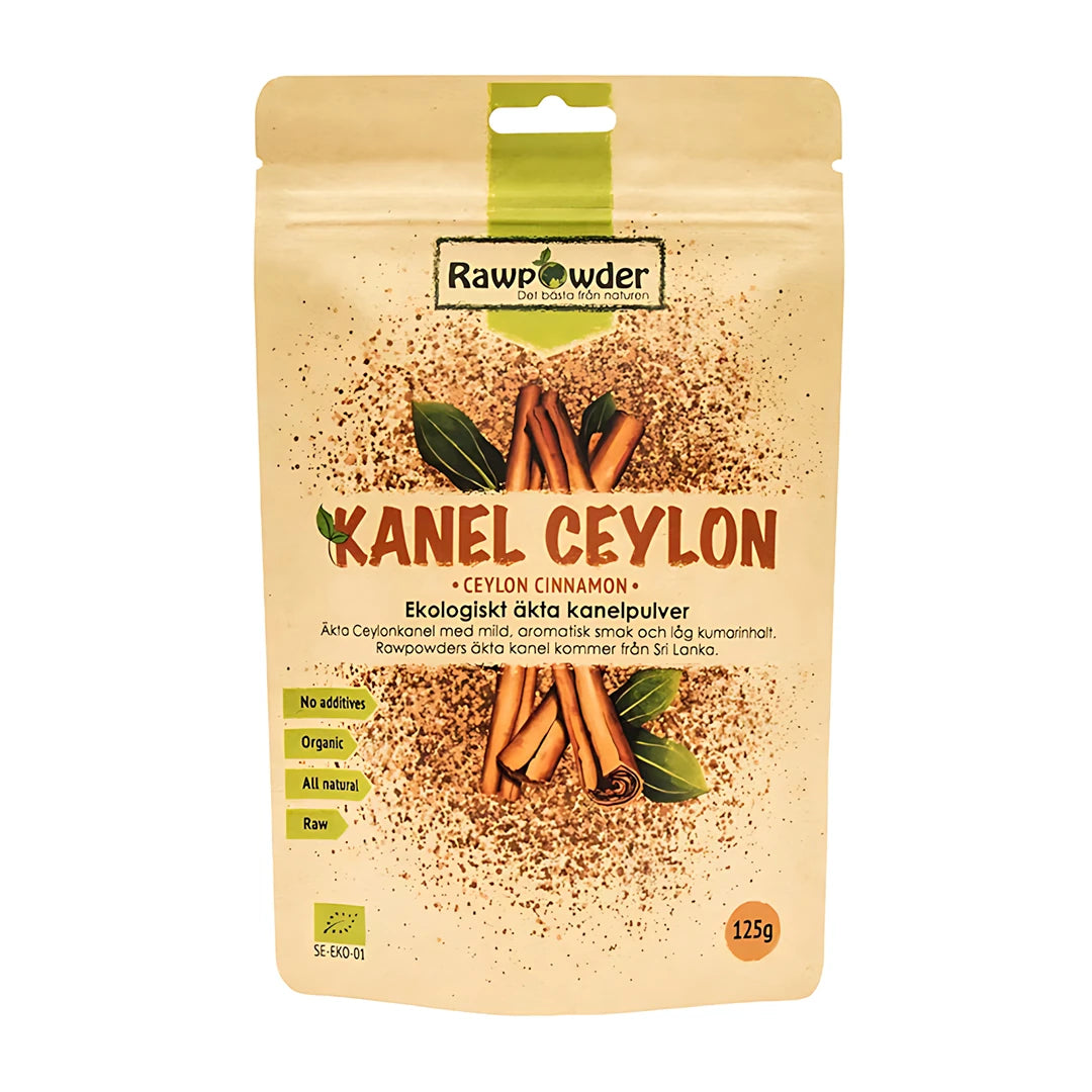 Rawpowder Kanel Ceylon 125 g -luomukanelijauhe beigessä pussissa, jossa on kanelitankojen ja vihreiden lehtien kuvia., kuva 1/1