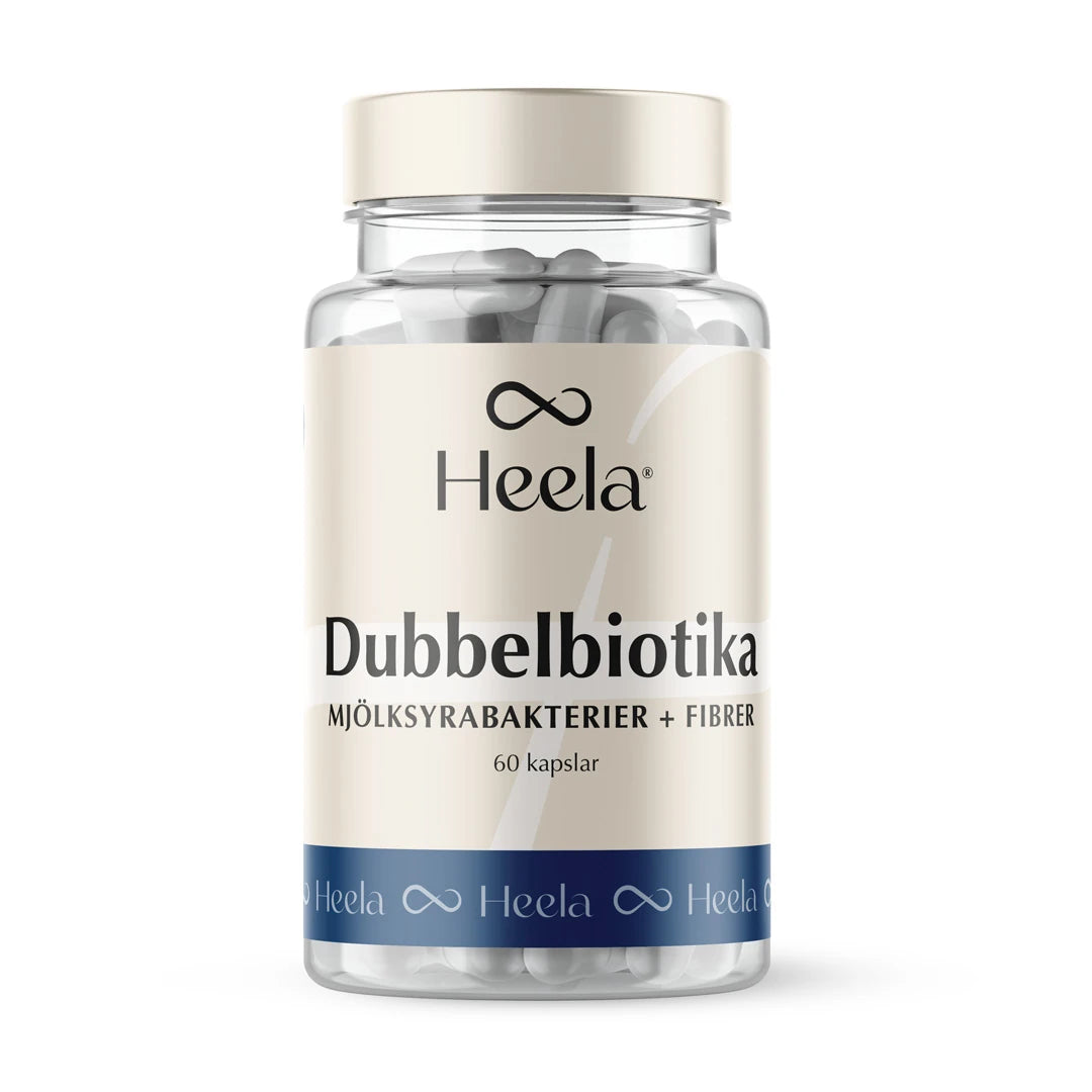 Heela Dubbelbiotika 60 caps läpinäkyvässä purkissa, jossa beige etiketti, siniset yksityiskohdat ja valkoiset kapselit., kuva 1/1