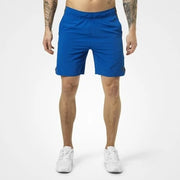 Better Bodies Brooklyn Shorts Strong Blue, blå träningsshorts för herr i vävd polyester på en manlig modell.