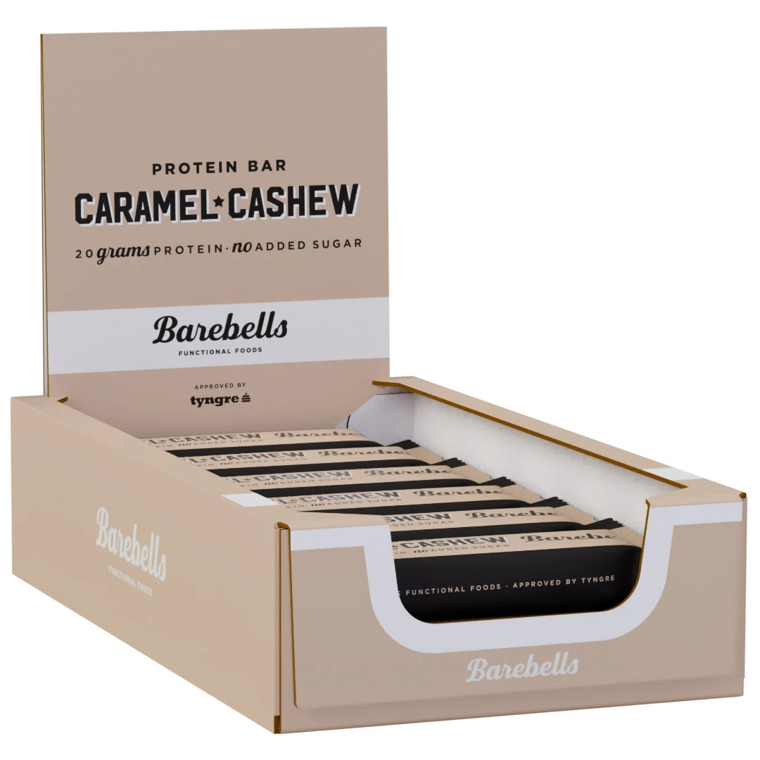 12 x Barebells Protein Bar 55 g Caramel and Cashew beigessä esittelylaatikossa, jossa on mustia ja beigejä proteiinipatukoita., kuva 1/1