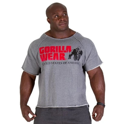 Mies yllään Gorilla Wear Classic Workout Top Grey, tilava harmaa t-paita raakareunoilla ja punaisella logolla.