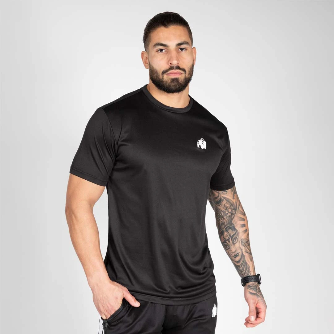 Gorilla Wear Fargo T-Shirt Black, musta treenipaita ilmavaa polyesteriä valkoisella logolla, mallin yllä., kuva 2/2
