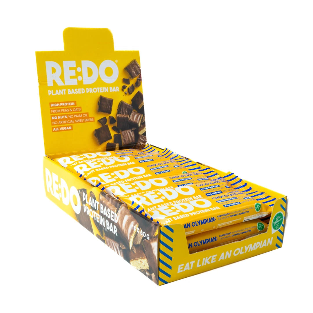 18 x REDO Bar 60 g Swedish Chocolate Ball keltaisessa esittelylaatikossa, jossa on vegaanisia proteiinipatukoita., kuva 1/1