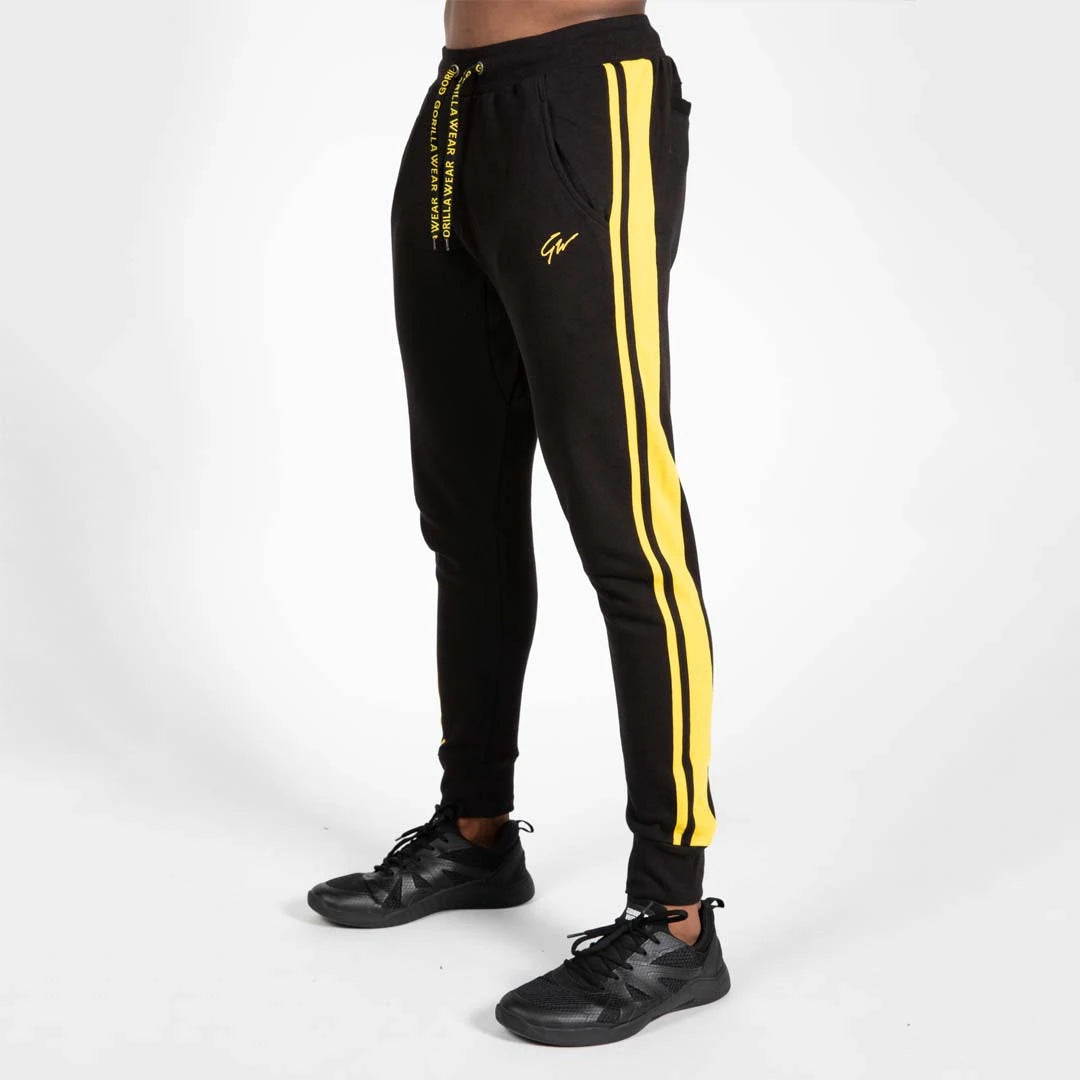 Gorilla Wear Banks Pants Black/Yellow - mustat treenihousut, joiden sivuilla on keltaiset raidat ja rento istuvuus., kuva 1/8