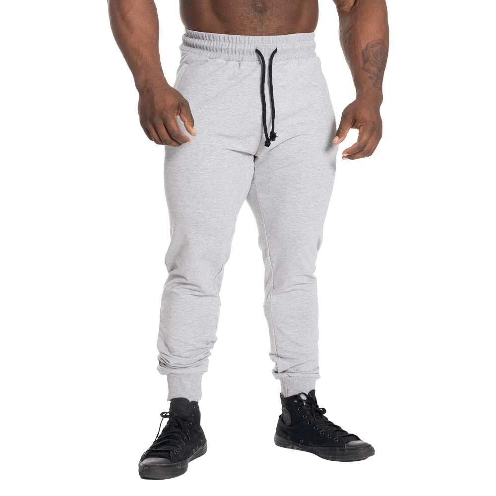 GASP Tapered Joggers Light Grey Melange ovat vaaleanharmaat kapenevat treenihousut, joissa on musta kiristysnauha.