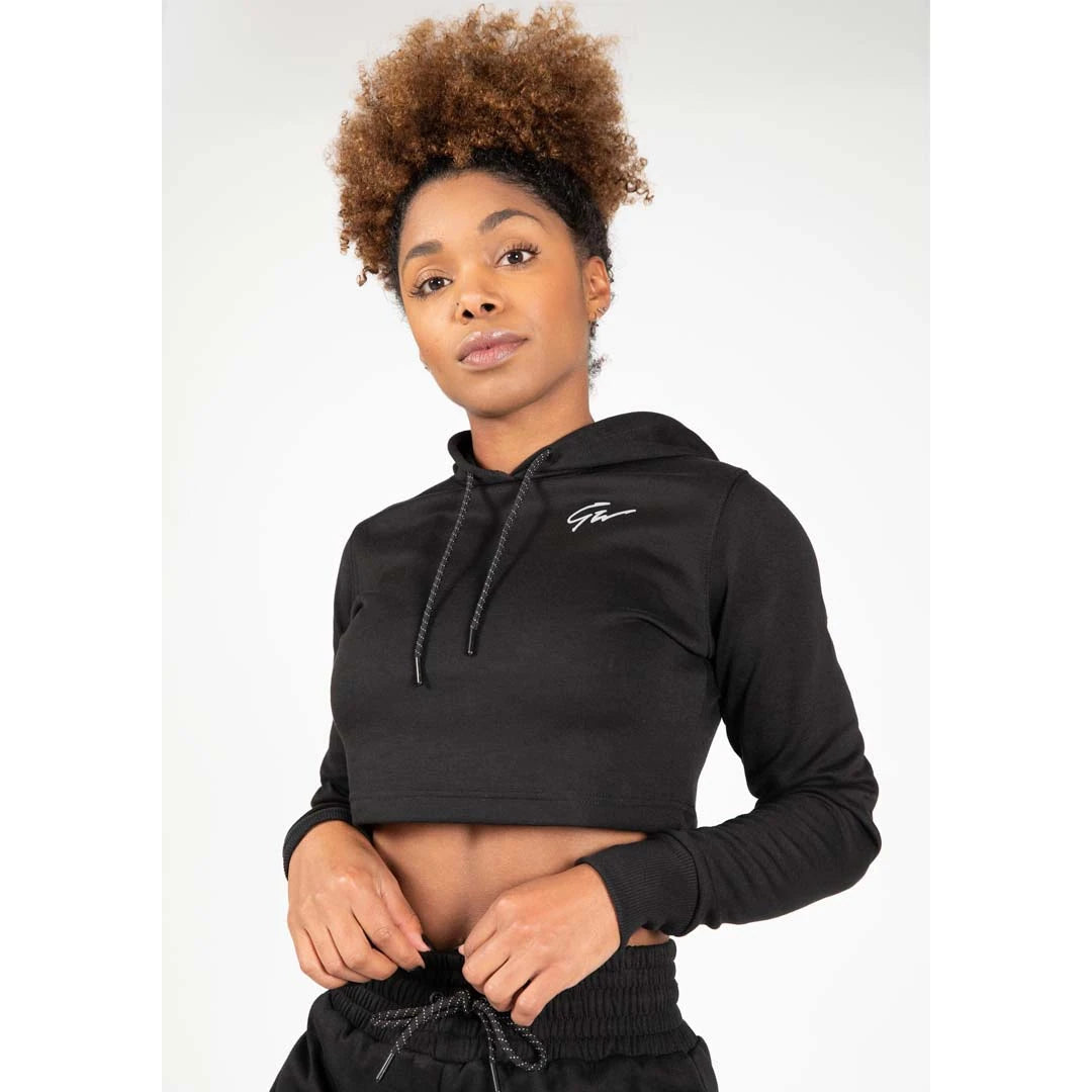 Gorilla Wear Pixley Crop Top Hoodie Black, musta lyhennetty slim fit -huppari kiristysnauhalla naisen yllä.